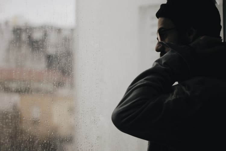 Man stares out window.