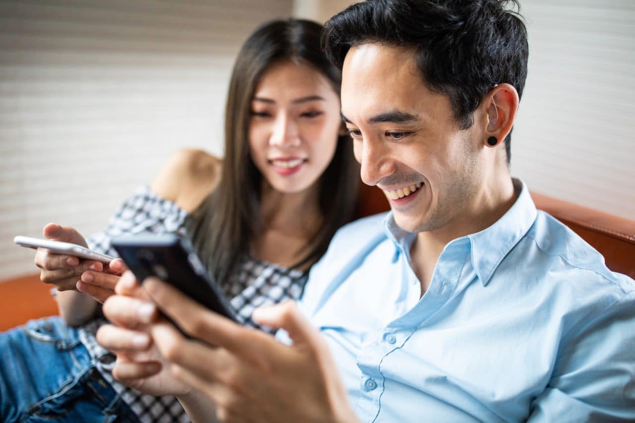 Man with a hearing aid uses a smartphone.