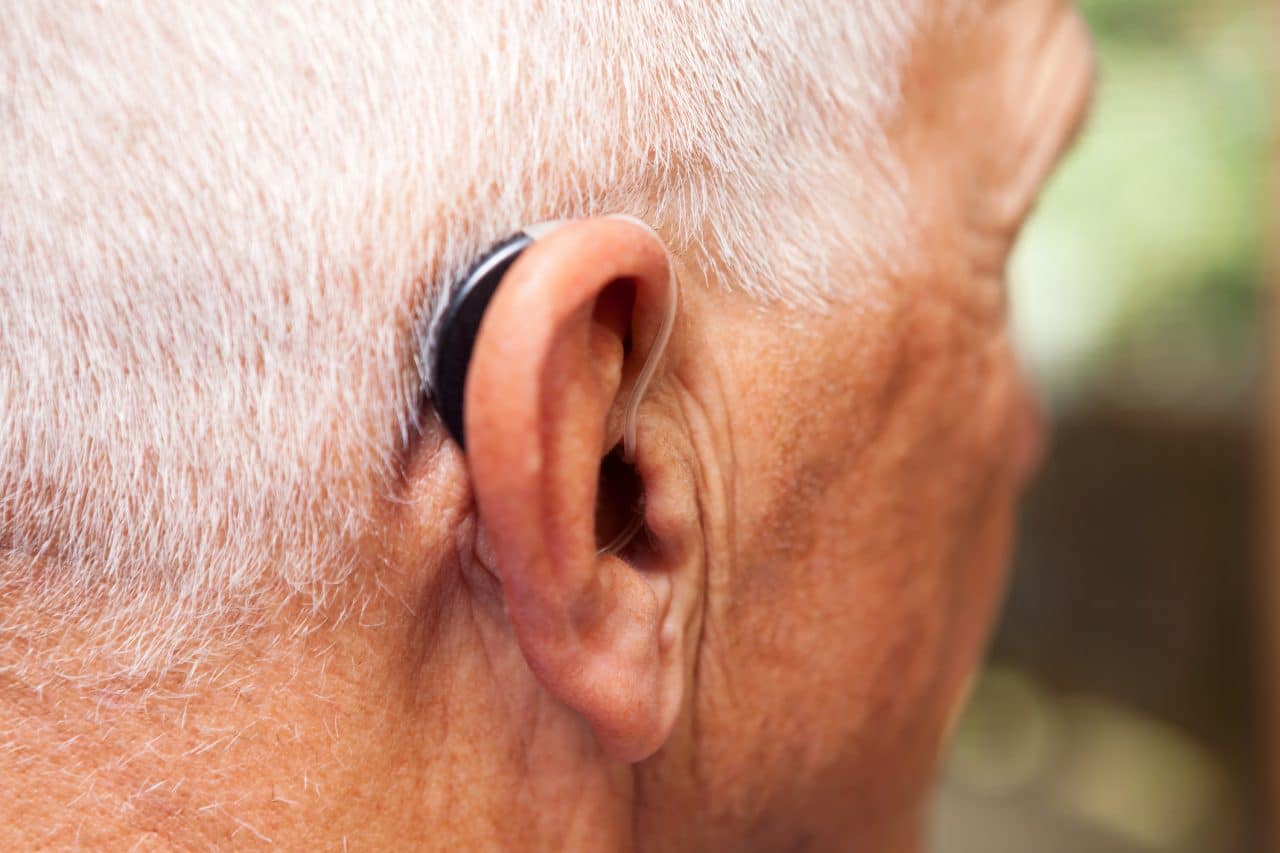 Man wearing a behind-the-ear-hearing aid.