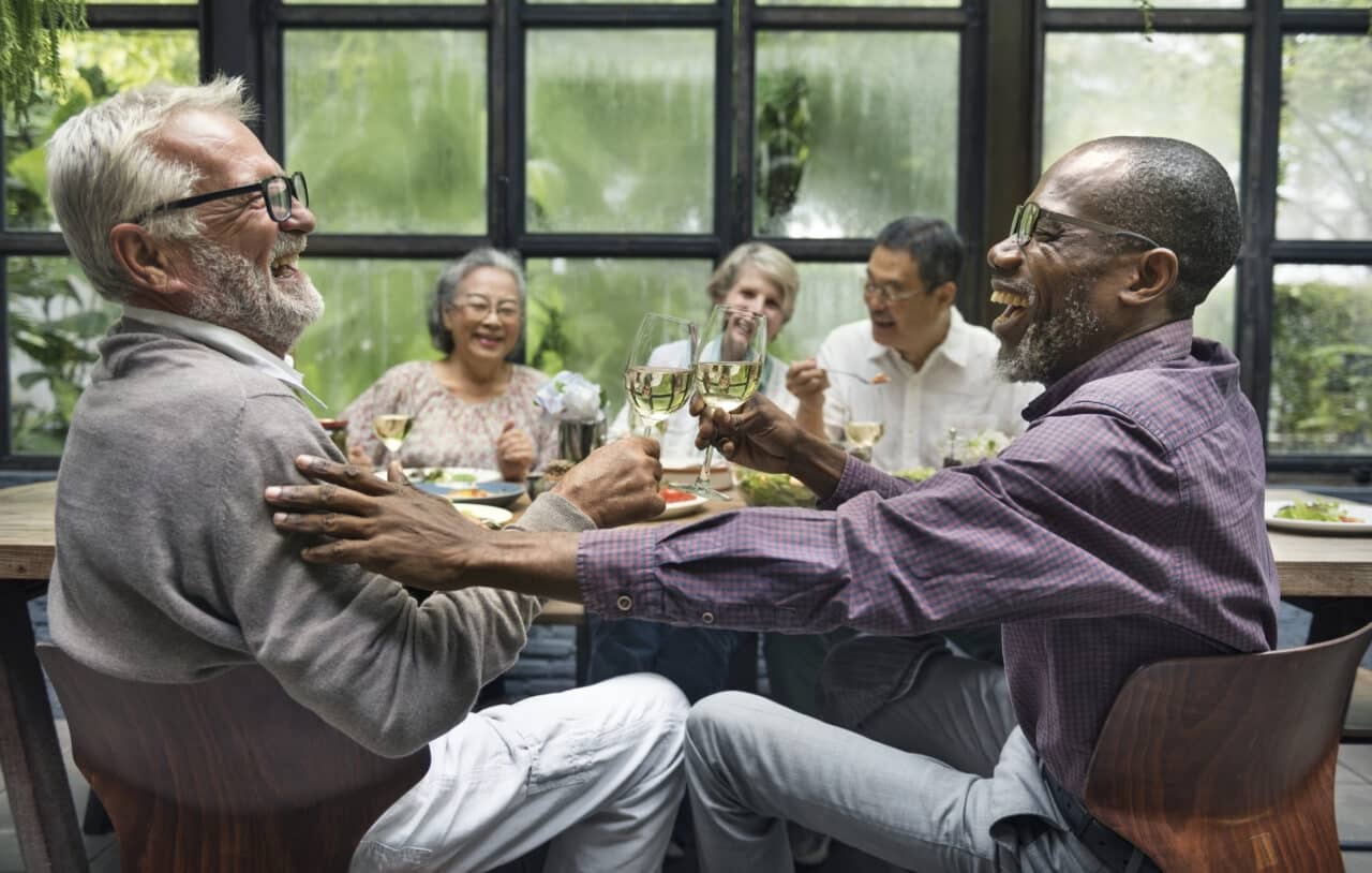 A group of older friends socializing at a dinner party.