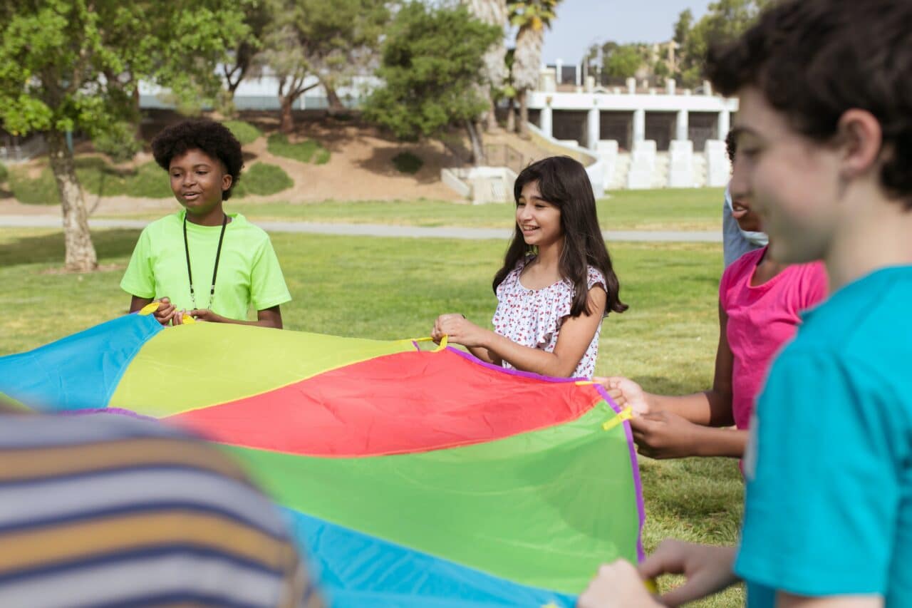 Kids playing with a parachute tent.