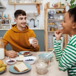 Teenager with hearing aids having lunch with a friend