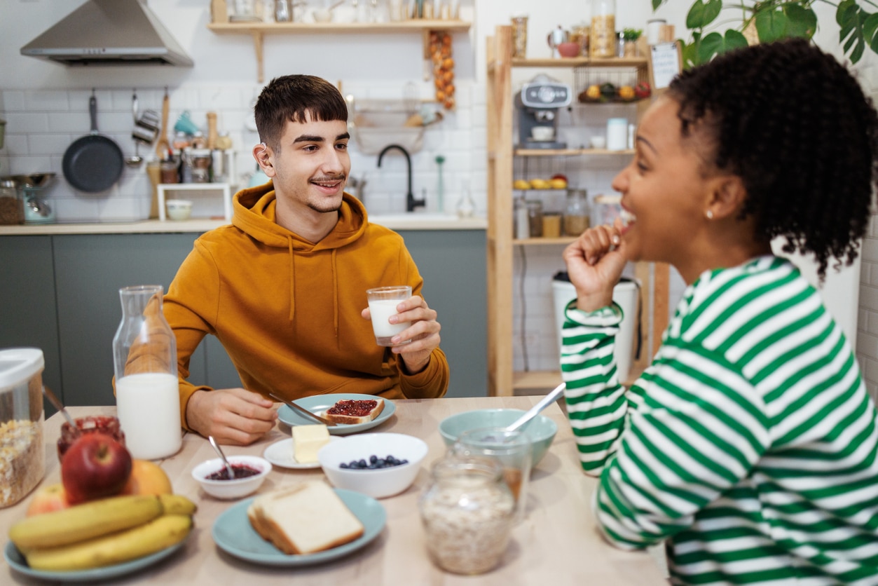 Teenager with hearing aids having lunch with a friend.