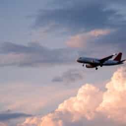 Plane landing or taking off with open landing gear on a beautiful sunset or sunrise colorful sky