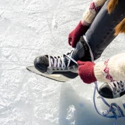 Woman lacing up her skates at the ice rink