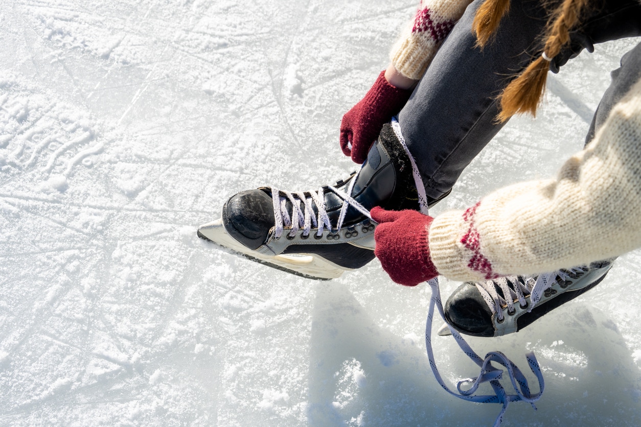 Woman lacing up her skates at the ice rink.